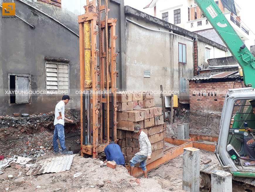 Công nhân thi công ép cọc bê tông gia cố móng ngôi nhà phố
