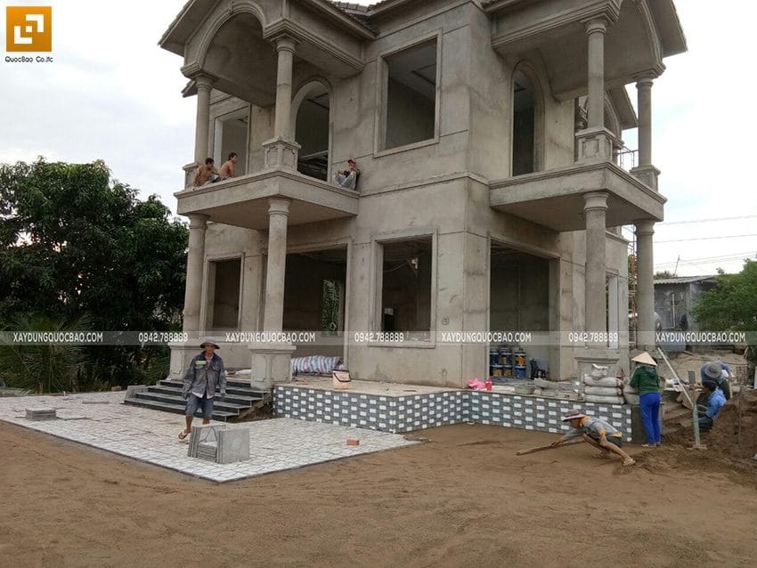Công nhân đang ốp gạch nền sân biệt thự