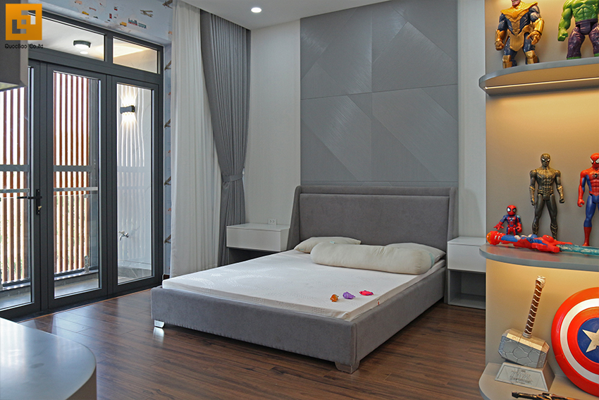 Phòng ngủ bé trai sử dụng gam màu trung trính, nổi bật với mảng tường màu xám ghi